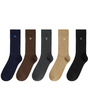 Five ribbed crew socks in navy, brown, charcoal, tan, and black, arranged in a row on a white background. Each sock has a small embroidered letter 'B' near the cuff.
