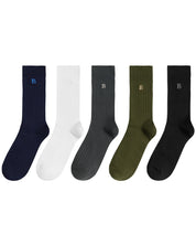 Five ribbed crew socks in navy, white, charcoal, olive green, and black, each with a small embroidered letter B near the cuff, arranged side by side on a white background.
